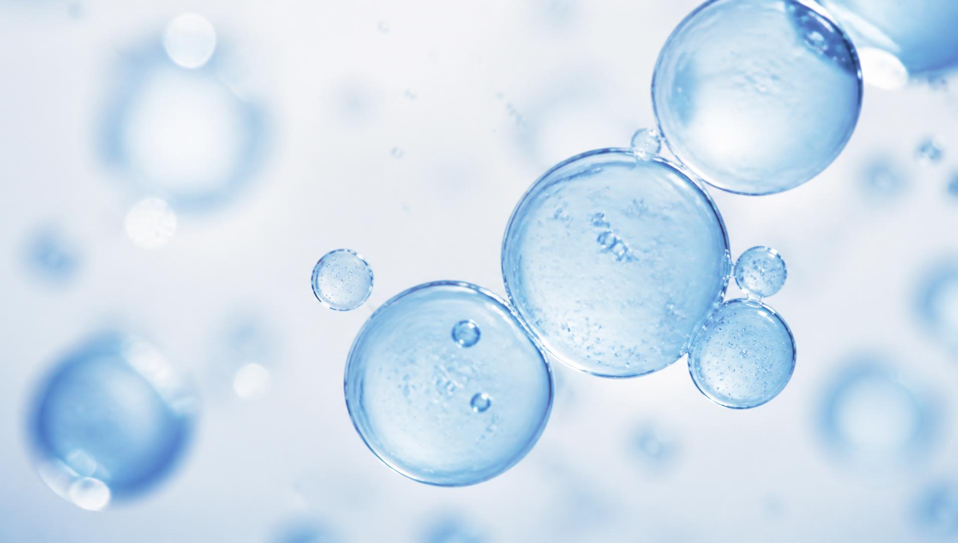 Translucent blue cell-like spheres viewed under high-key microscopy lighting